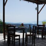 Trattoria rustica tra le colline, tavoli all'aperto e piatti tradizionali tipici.