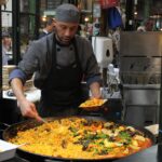 Immagine di una vivace scena gastronomica in una città europea, con piatti tipici e ristoranti affollati.