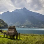 Lago con acque cristalline circondato da montagne, simile a un fiordo norvegese.